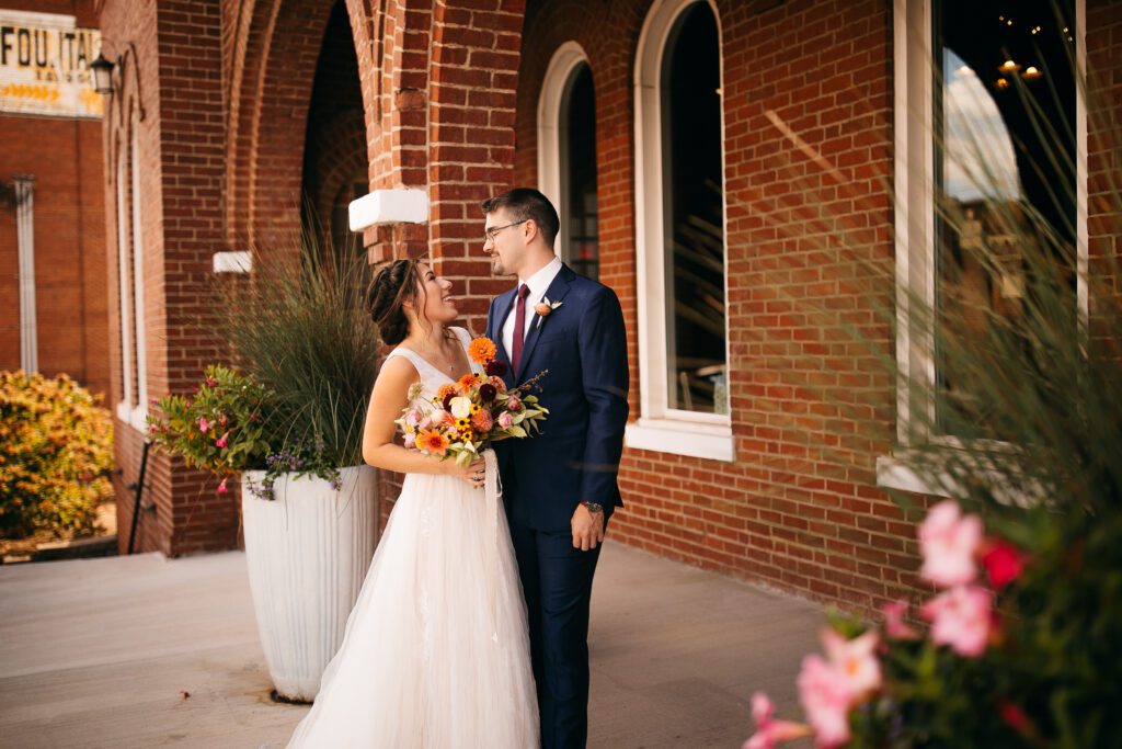 Wedding venue in Chattanooga showcasing married couple outside of a red, brick church.