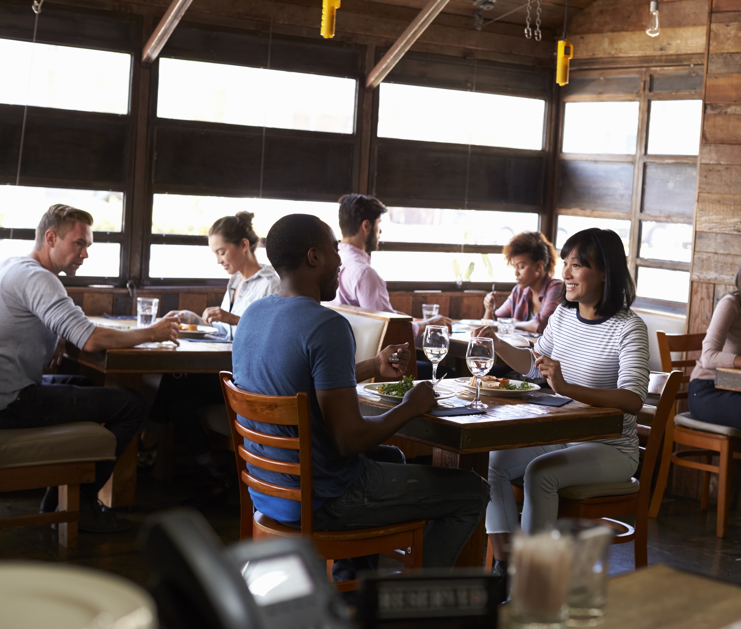 Couples enjoying lunch in a busy restaurant Wedding packages in chattanooga showcasing a bride and groom standing on stage preparing to be married.