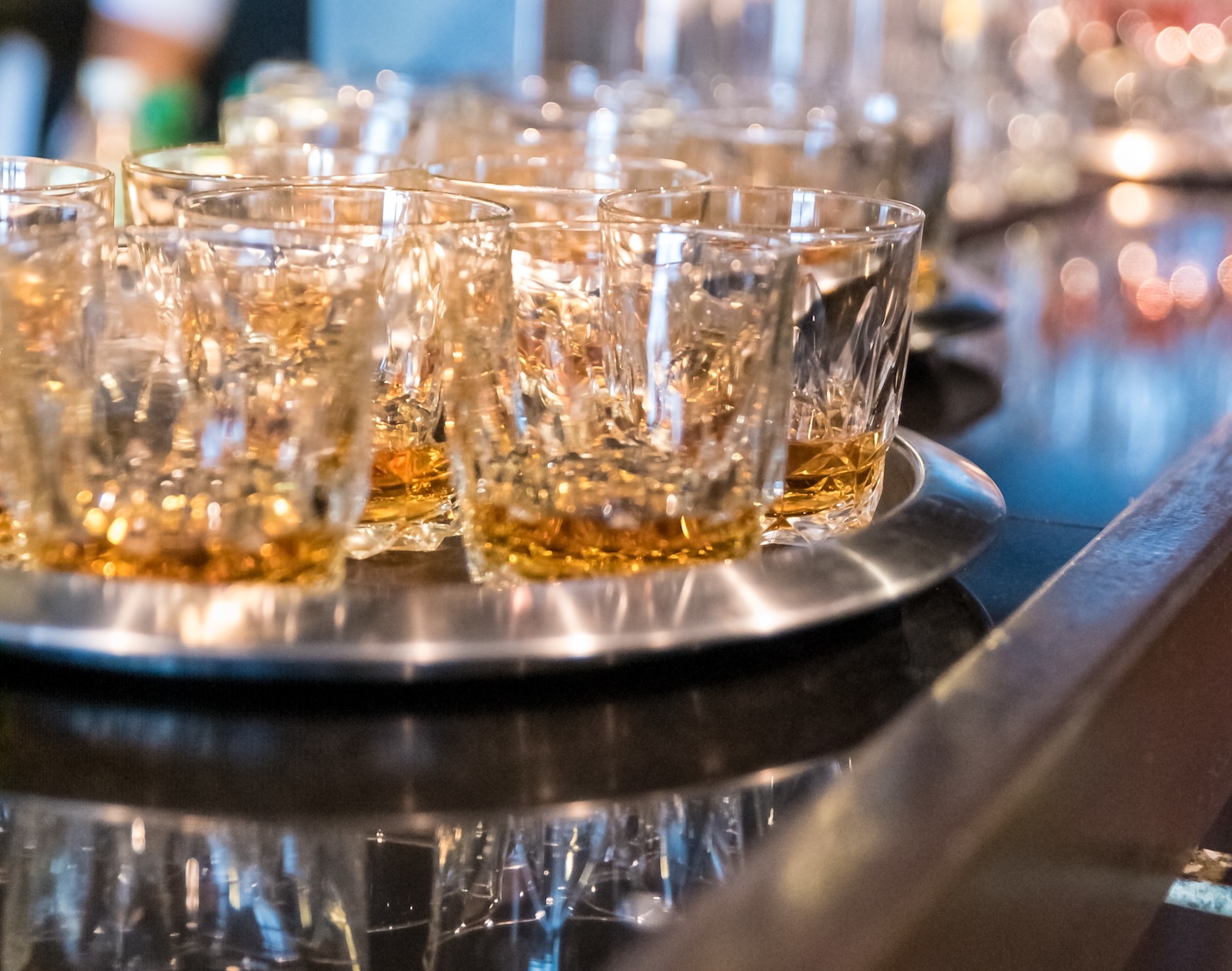 Vertical shot of alcohol drinks in a metal tray at a wedding reception Wedding packages in chattanooga showcasing a bride and groom standing on stage preparing to be married.