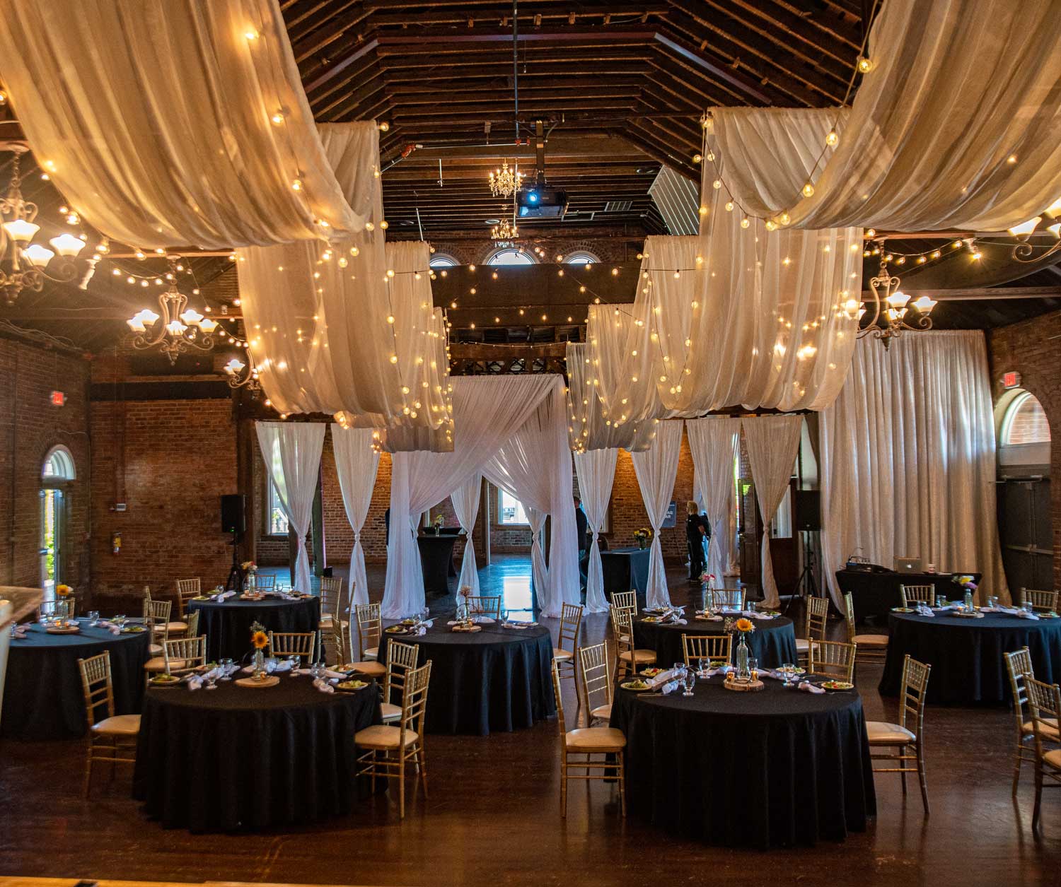 Wedding packages in chattanooga showcasing married couple standing on a stage with white drapes hanging from the ceiling.