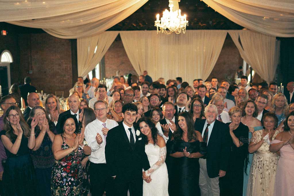 Wedding venue in Chattanooga showcasing 2 girls in dresses holding flowers standing outside of a red brick church.